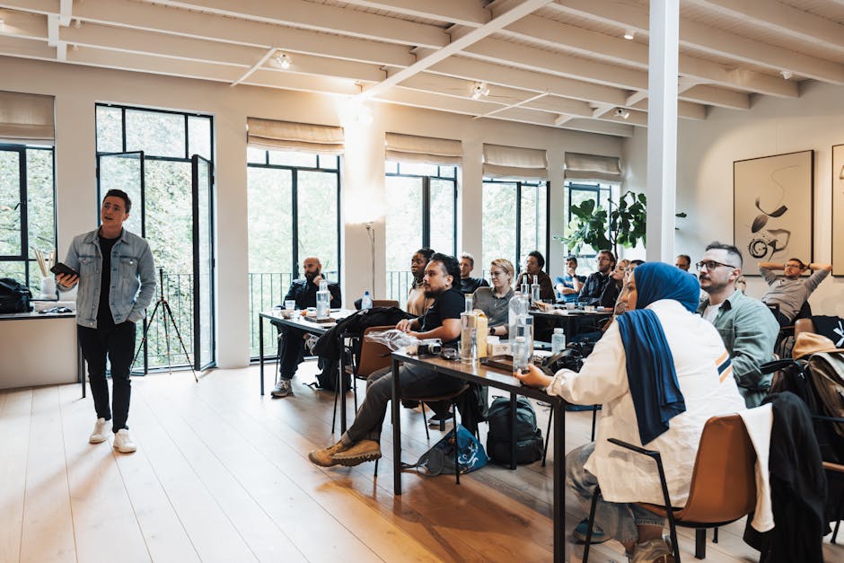 Diverse group attending workshop, focused on speaker presenting in modern indoor setting.